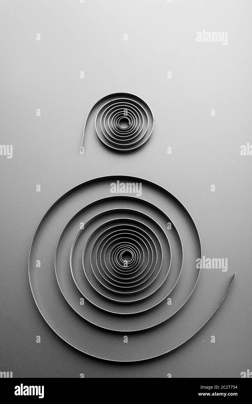 Two abstract metallic spirals on grey background Stock Photo