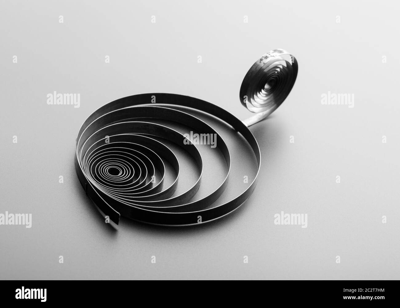 Two metallic spirals on grey background Stock Photo