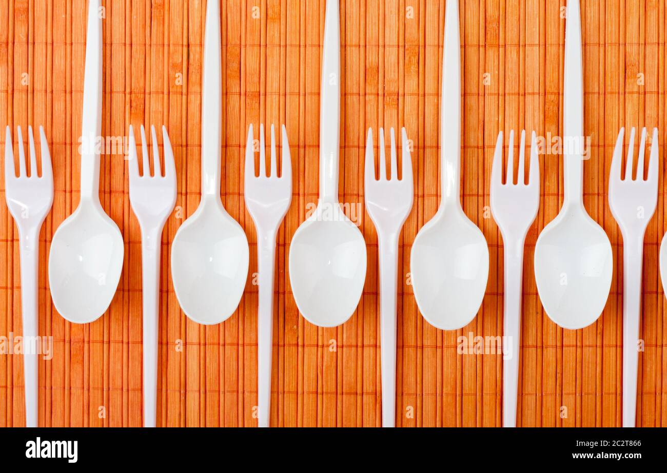 A row of plastic silverware. Spoons and forks Stock Photo Alamy