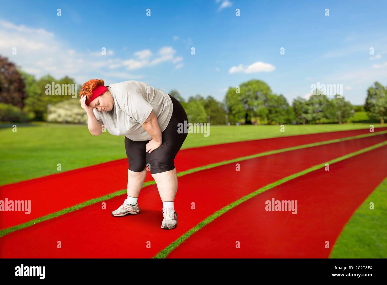 Overweight tired female runner on a jogging track outdoors. Calories