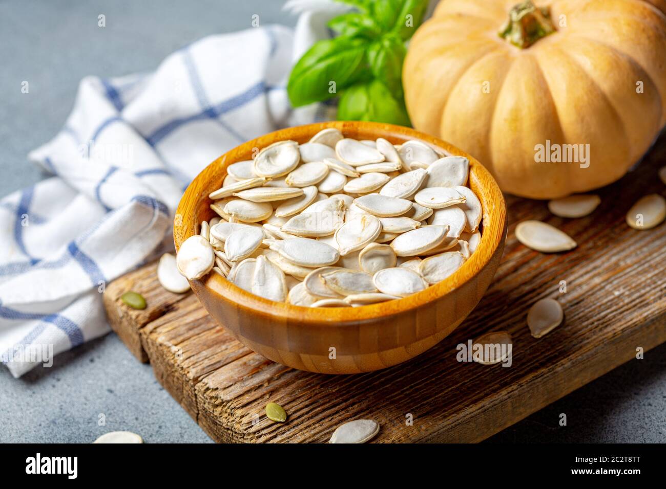 Unpeeled pumpkin seeds in a wooden bowl. Stock Photo