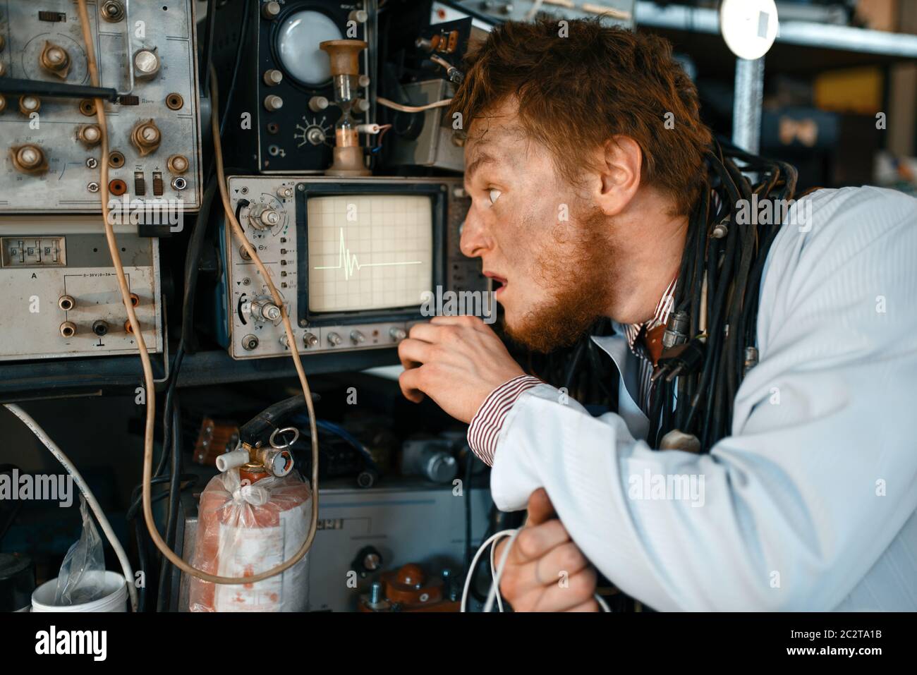 Crazy engineer looks on oscilloscope display in laboratory. Electrical