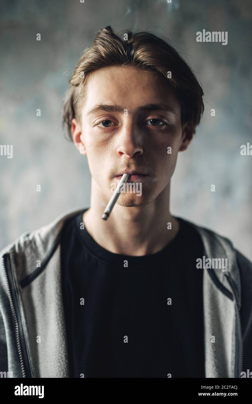 Young man smoke cigarette, grunge background. Addiction concept, smoking  drugs Stock Photo - Alamy