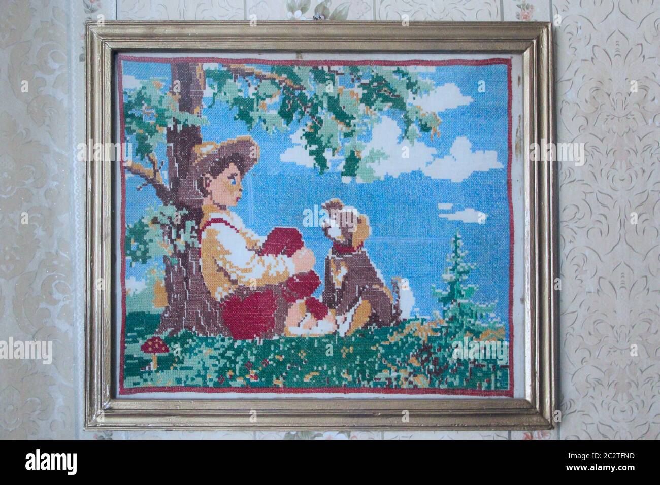 Old picture of boy with dog embroidered with cross. Image of boy and dog cross stitch Stock Photo