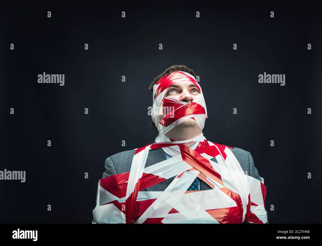 Victum man with stripped  red and white duct tape over body Stock Photo