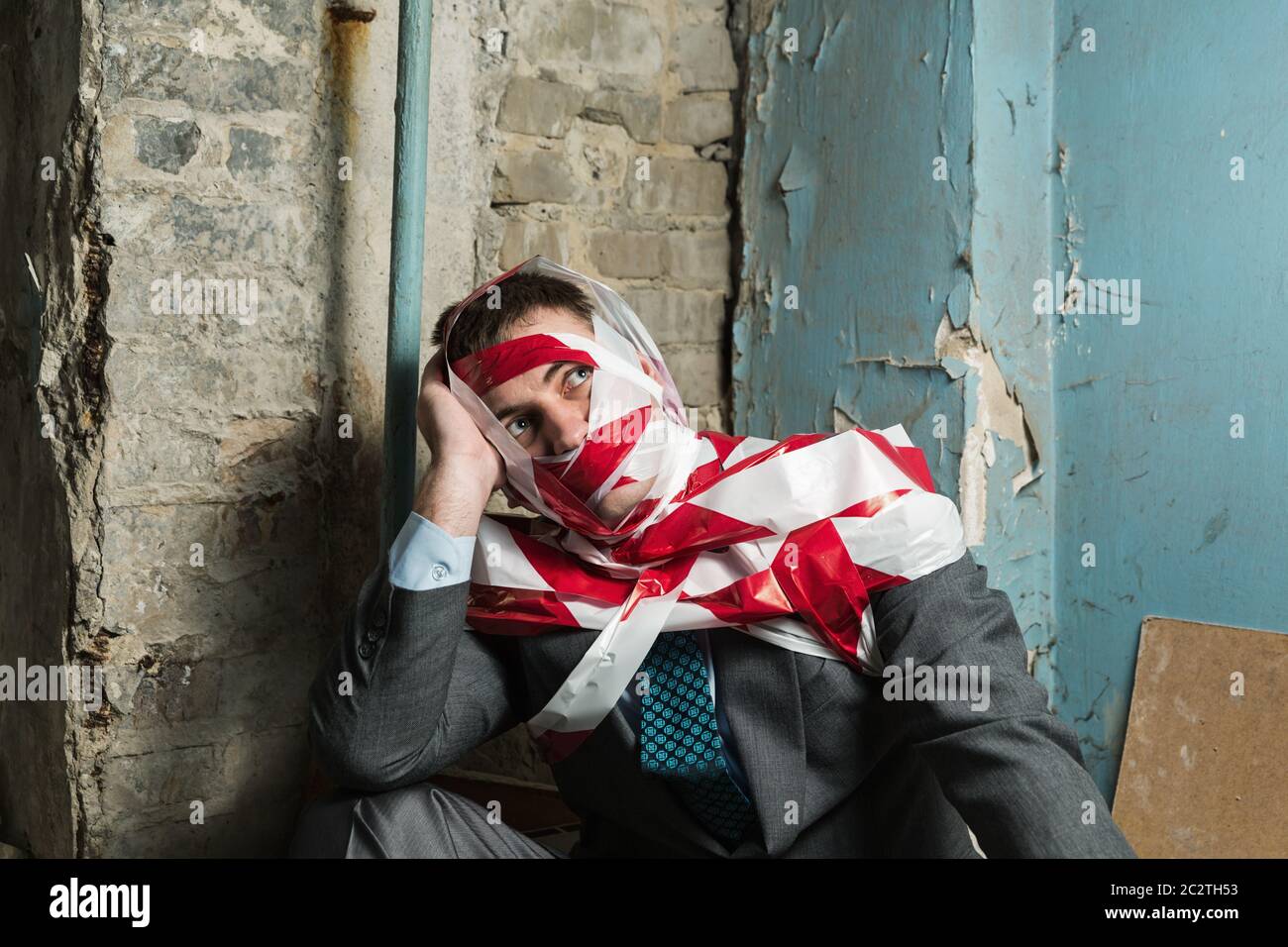 Victum man with stripped duct tape over body in old house Stock Photo