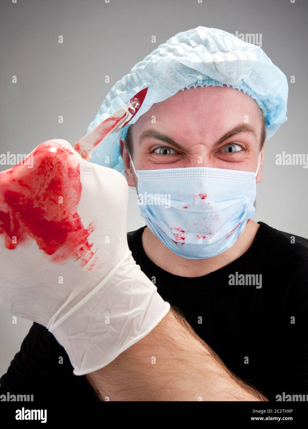 Mad mental sick blood soiled surgeon with knife Stock Photo