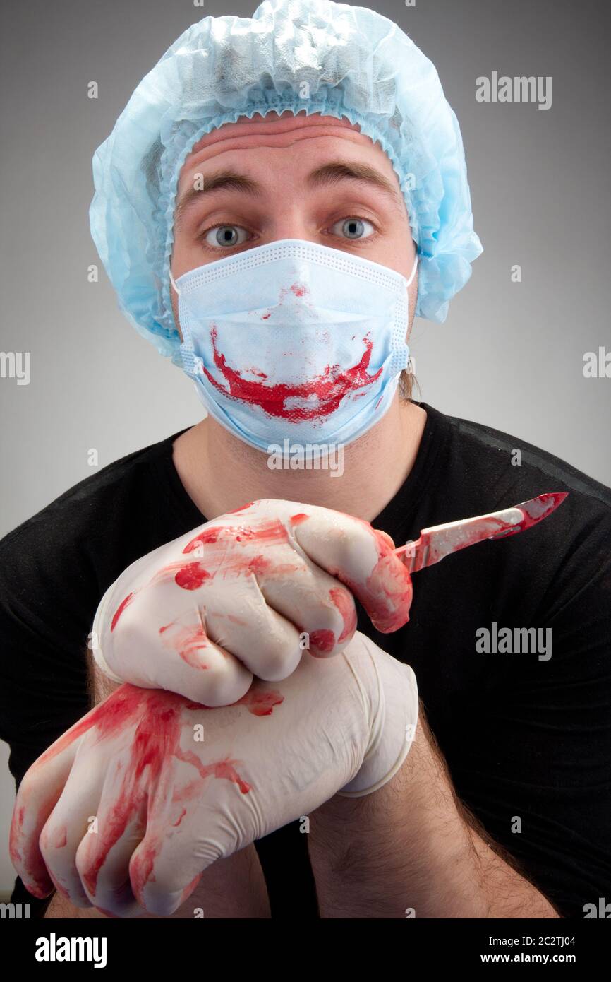Mental sick blood soiled surgeon with knife Stock Photo