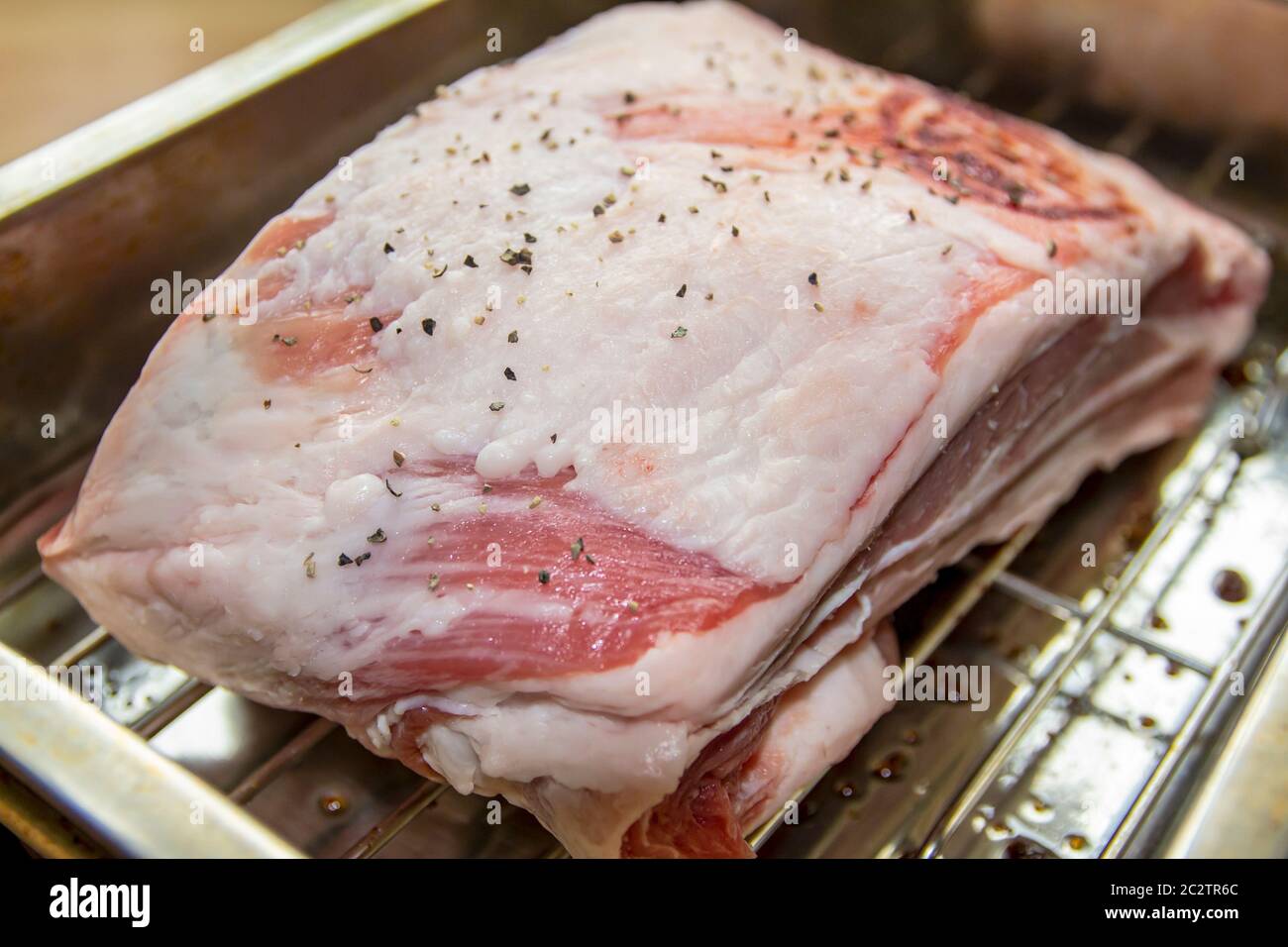 Closeup of a small Joint of Lamb on a rack with Salt and Black Pepper