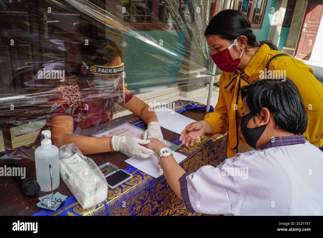 Badung, Bali, Indonesia. 17th June, 2020. Plastic shield divider separates school administrators and students. Widiatmika school of Jimbaran applying health protocols towards document management of their graduated students to prevent Covid-19 coronavirus for further spreading. (Credit Image: © Dicky BisinglasiZUMA Wire) Stock Photo