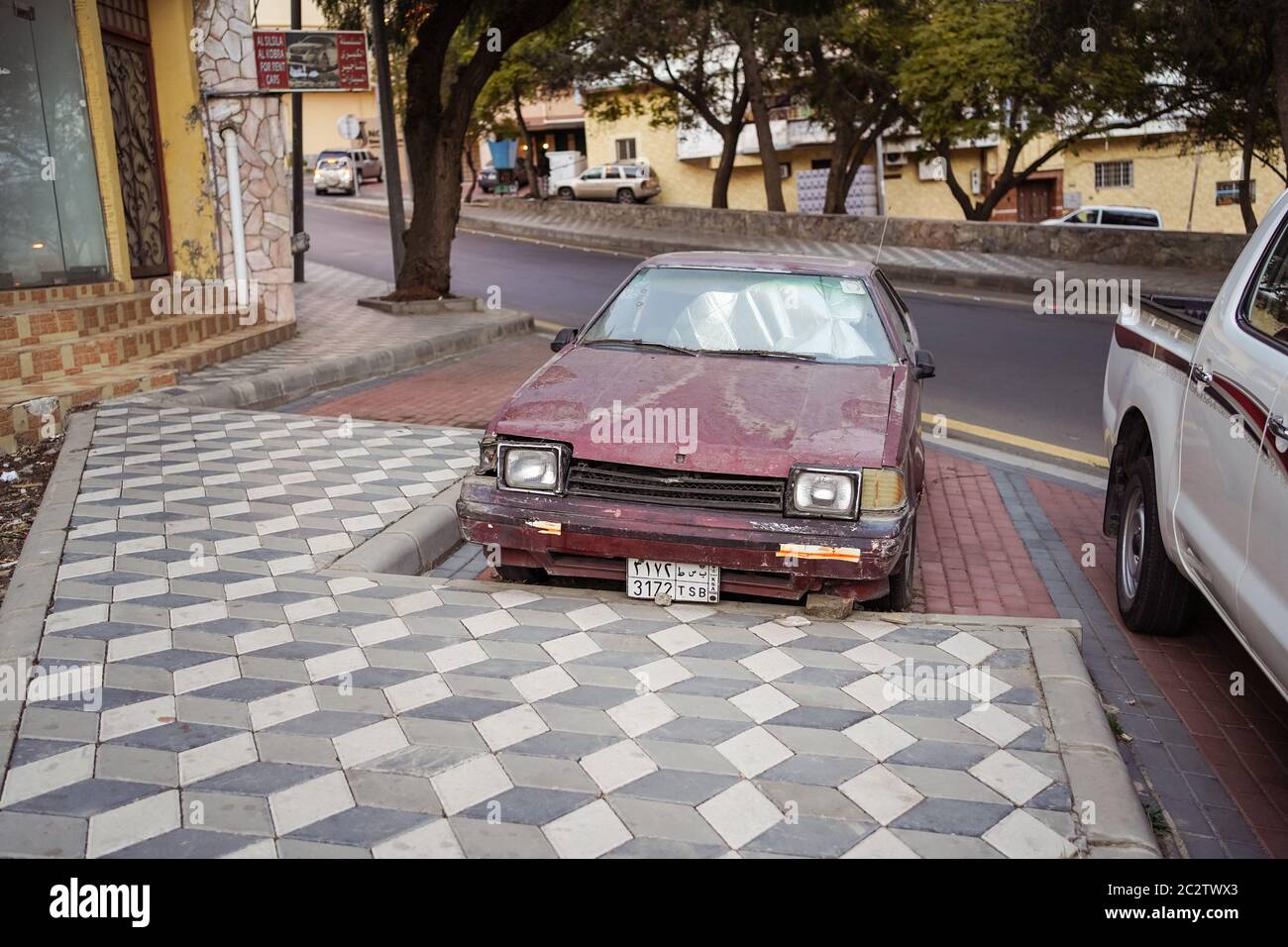 Abha / Saudi Arabia - January 23, 2020: old and rusty red car parked on the street Stock Photo