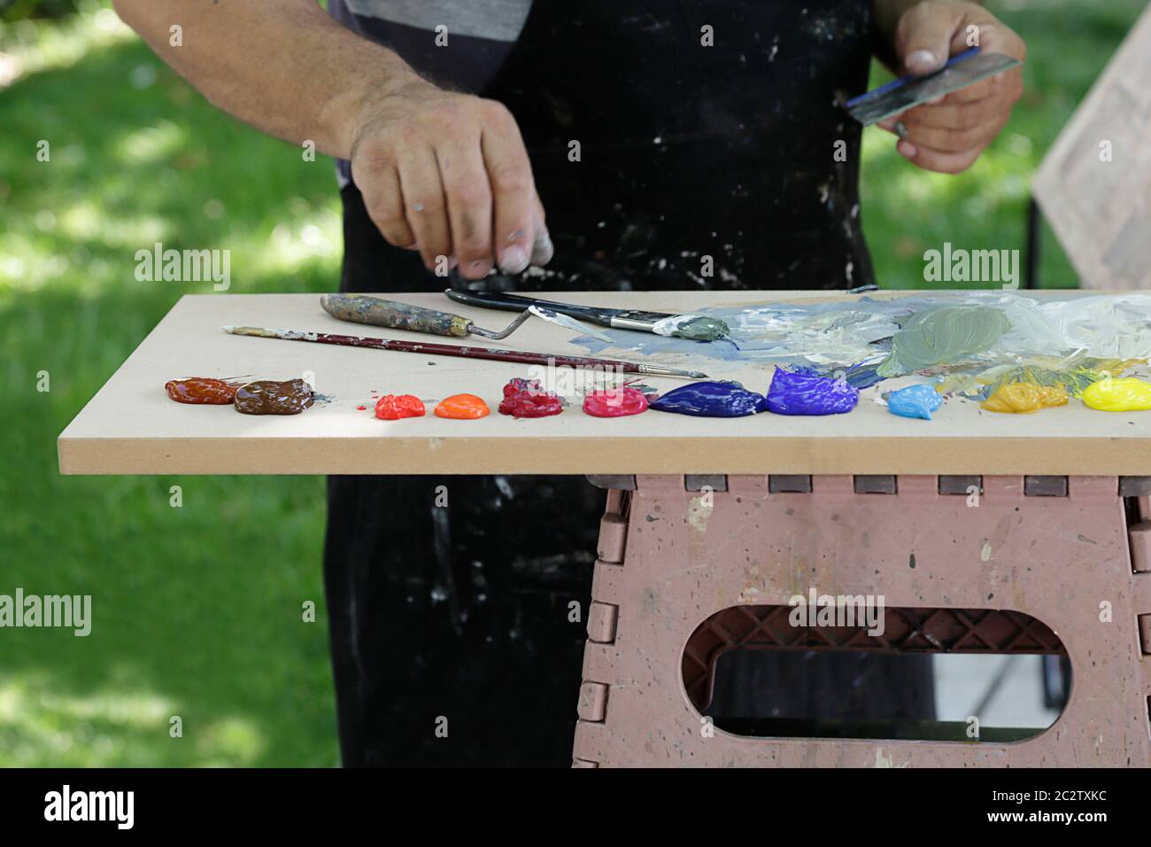 A painter using paint utensils (oil paint, artist brush and a palette knife Stock Photo Alamy