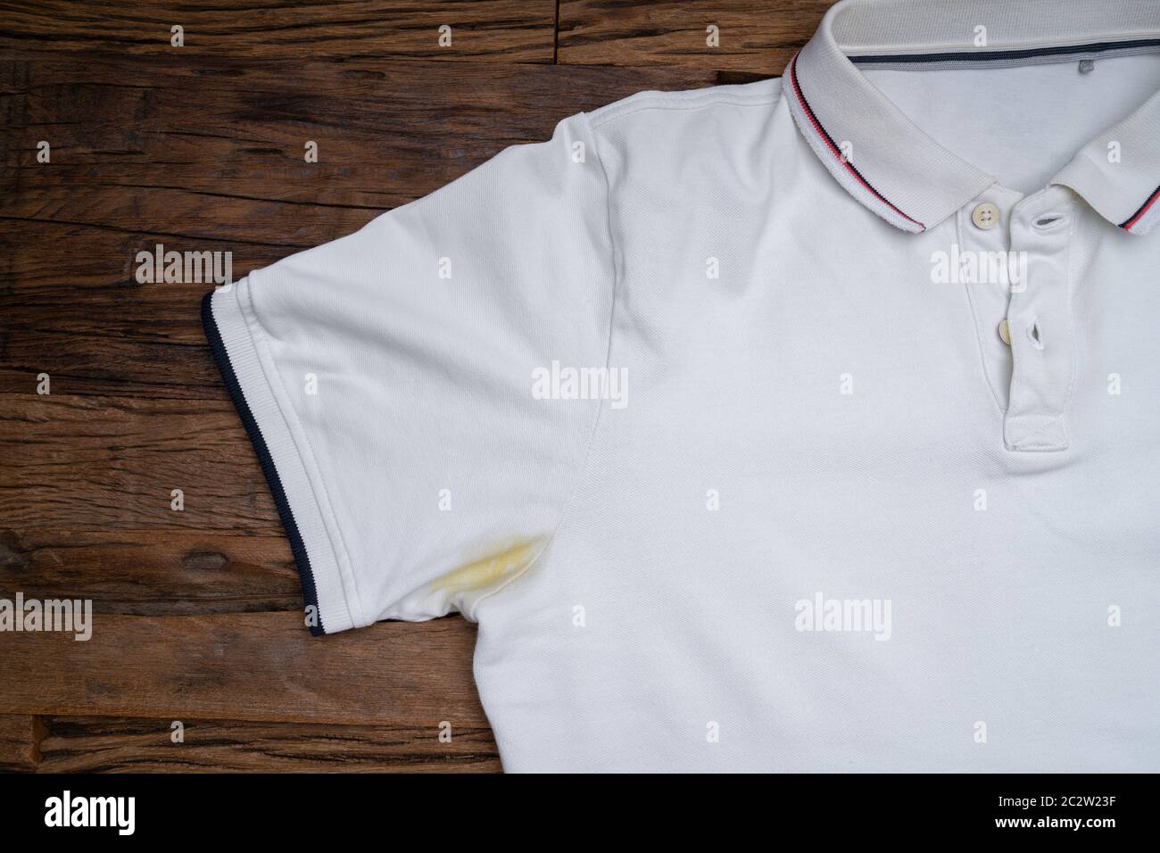 Yellow Stain Under Armpit On White Tshirt Over The Wooden Desk Stock