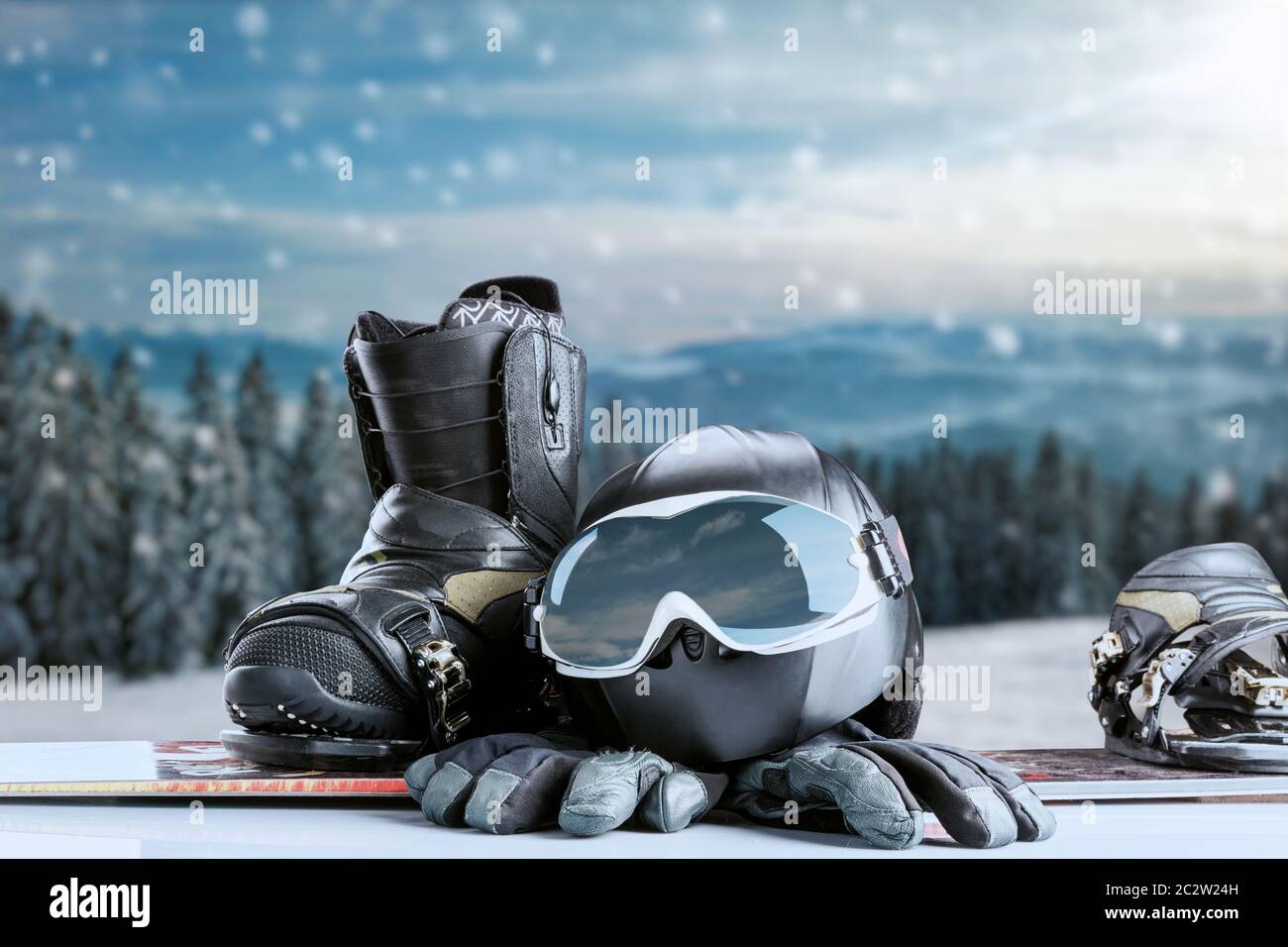 Winter sport glasses, snowboarding boot, helmet and gloves on winter