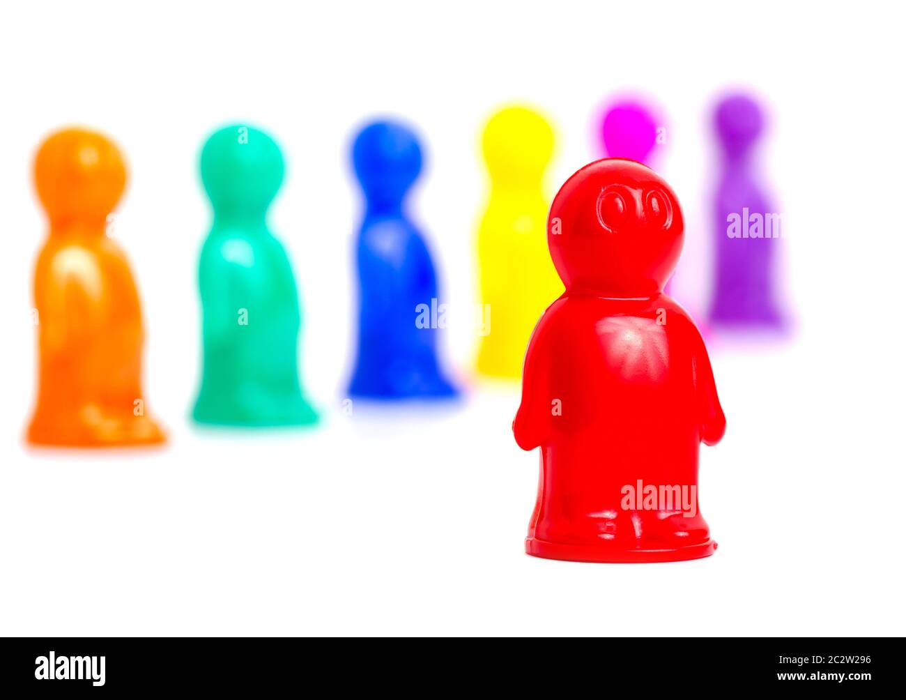 Standing out of the crowd concept. Colorful toy people group on white