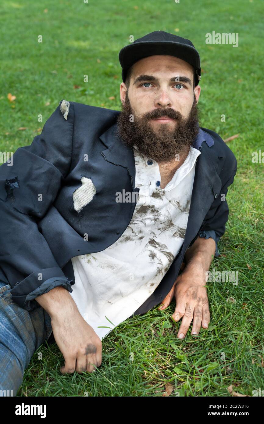 Bearded homeless lying on the lawn Stock Photo
