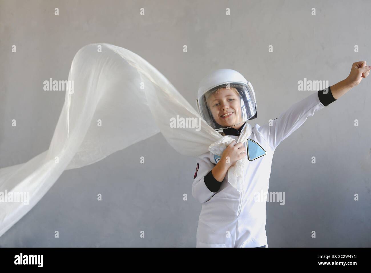 Astronaut futuristic kid girl with white full length uniform and helmet Stock Photo