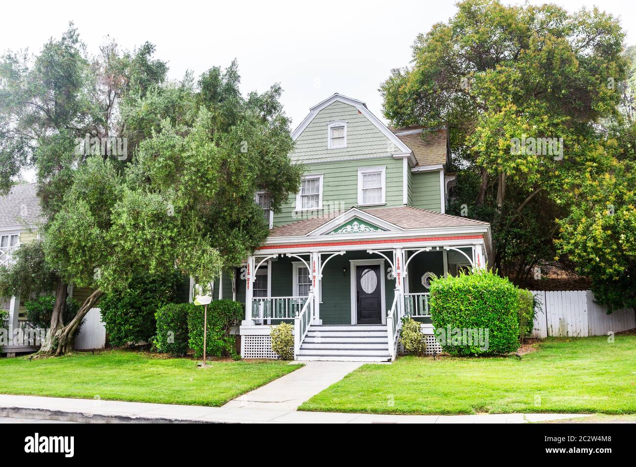Cozy house decorated with green trees and plants Stock Photo - Alamy