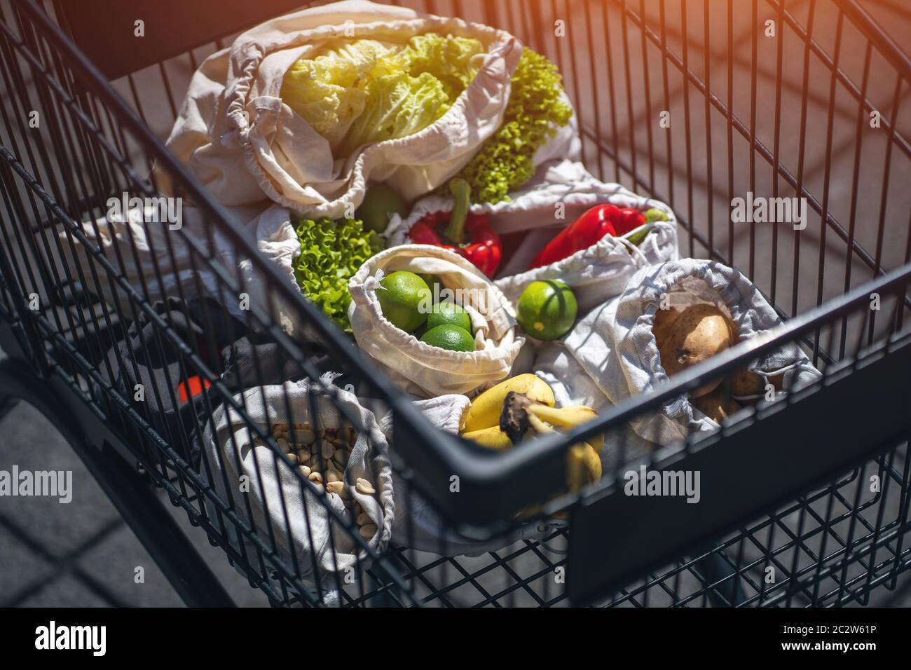 set of reusable and zero waste cotton shopping bags for food in cart