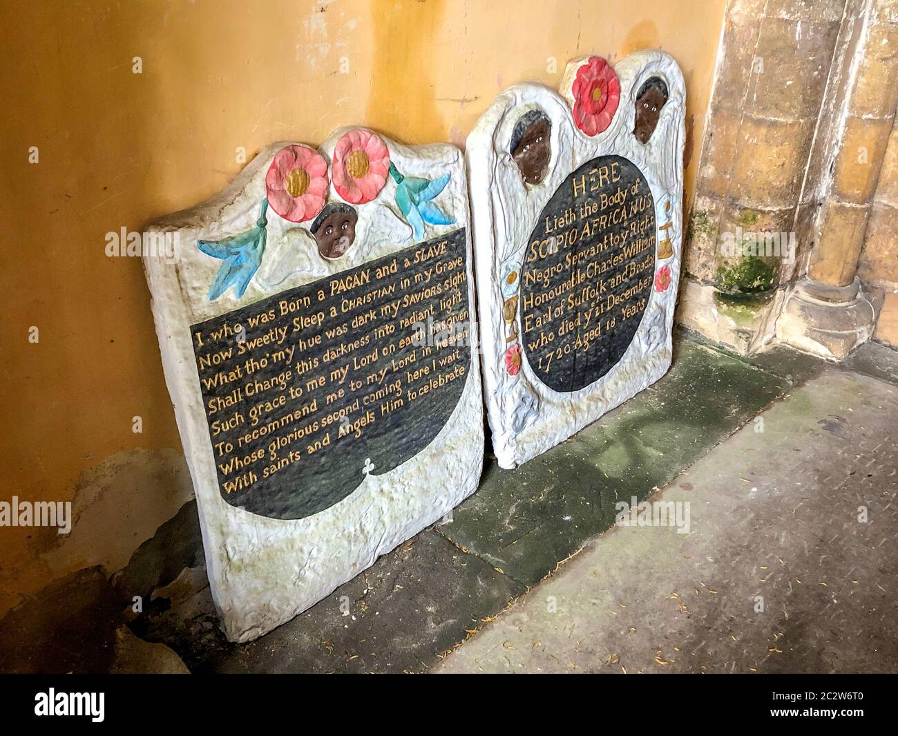 Two headstones in the entrance to St Mary's church in Henbury, Bristol, where the grave of an enslaved African man has been vandalised in an apparent 'retaliation attack' following the toppling of a statue of slave trader Edward Colston in Bristol. Two headstones on the Grade II-listed, brightly painted memorial to Scipio Africanus have been smashed and a message was scrawled in chalk on flagstones nearby. Stock Photo