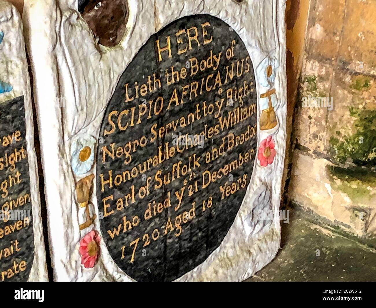 A headstone in the entrance to St Mary's church in Henbury, Bristol, where the grave of an enslaved African man has been vandalised in an apparent 'retaliation attack' following the toppling of a statue of slave trader Edward Colston in Bristol. Two headstones on the Grade II-listed, brightly painted memorial to Scipio Africanus have been smashed and a message was scrawled in chalk on flagstones nearby. Stock Photo