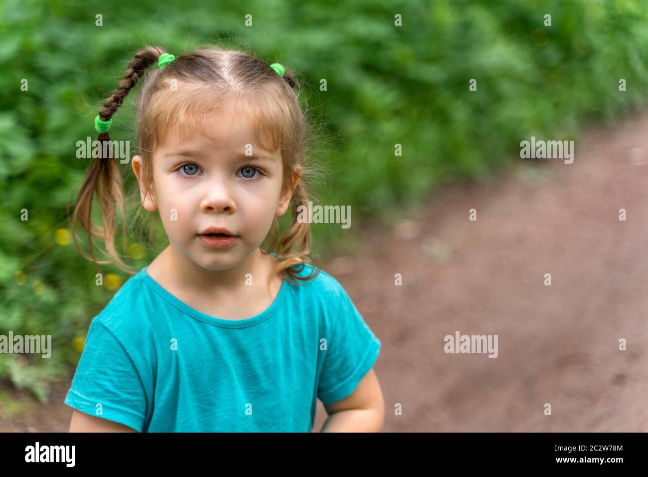 portrait of a little girl with blue eyes in the forest Stock Photo