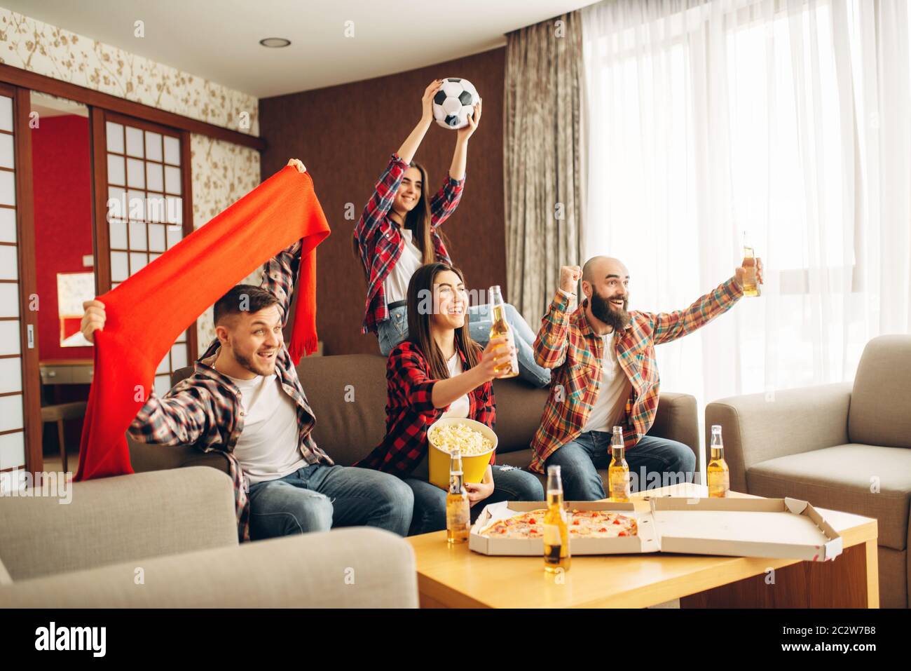 Smiling friends cheer for their favorite team, football fans. Group of