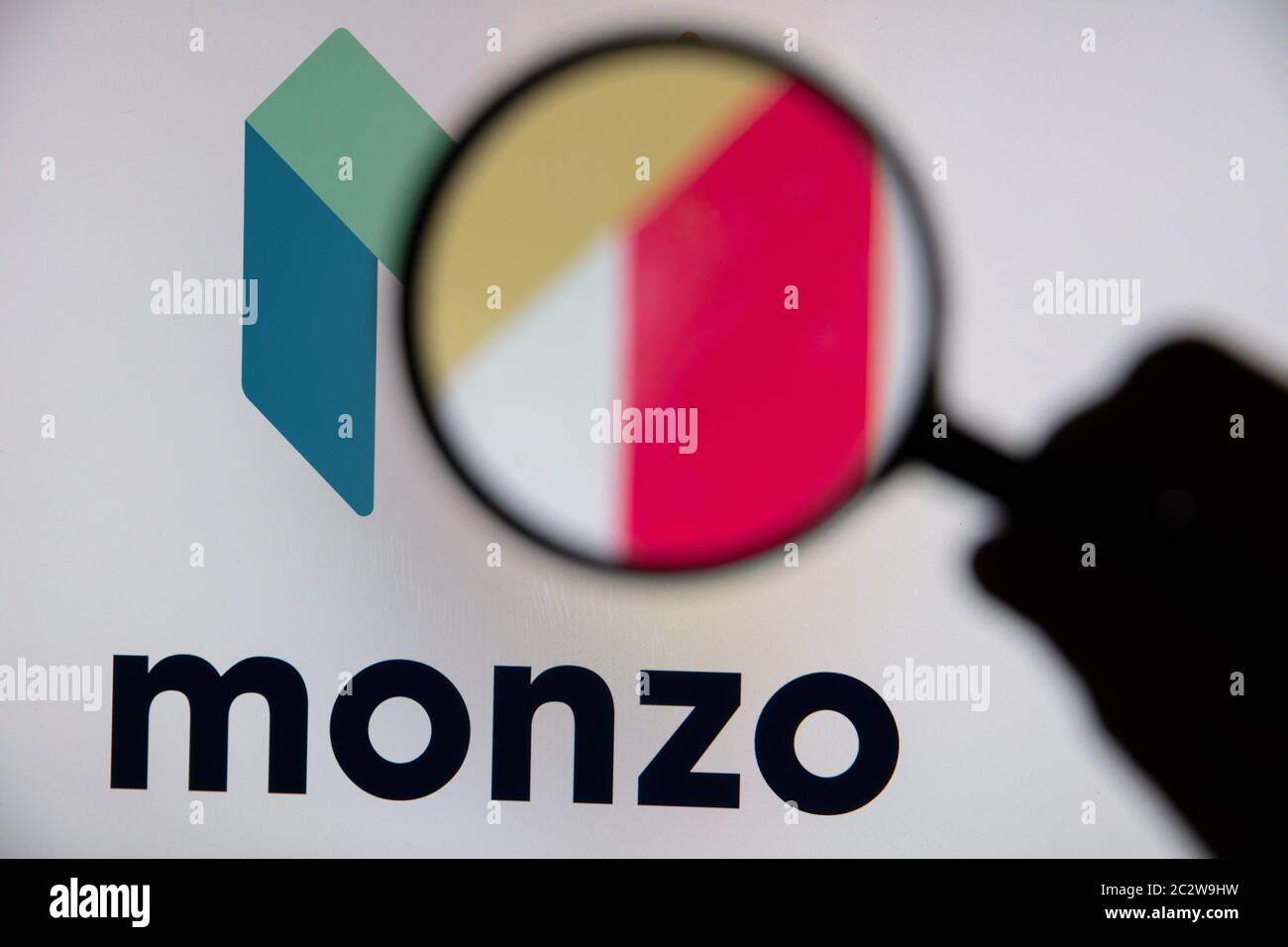 LONDON, UK - June 2020: Monzo online banking logo under a magnifying glass Stock Photo