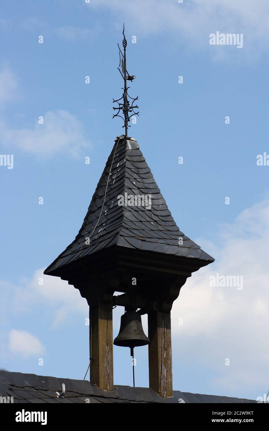 a small bell tower with blue sky in background Stock Photo
