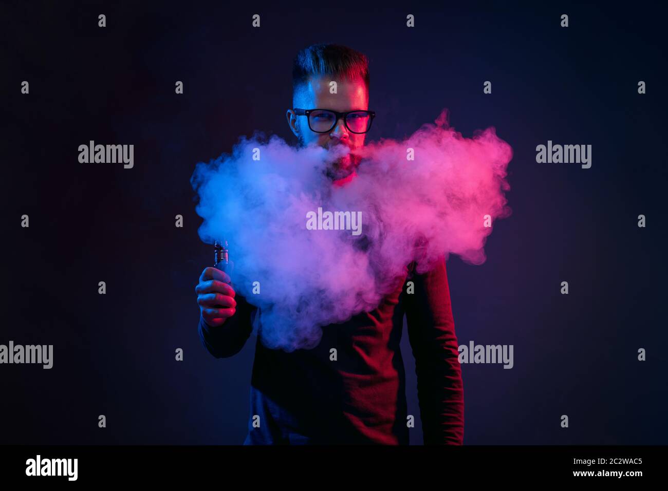 Vaping flavored e-liquid from an electronic cigarette Stock Photo