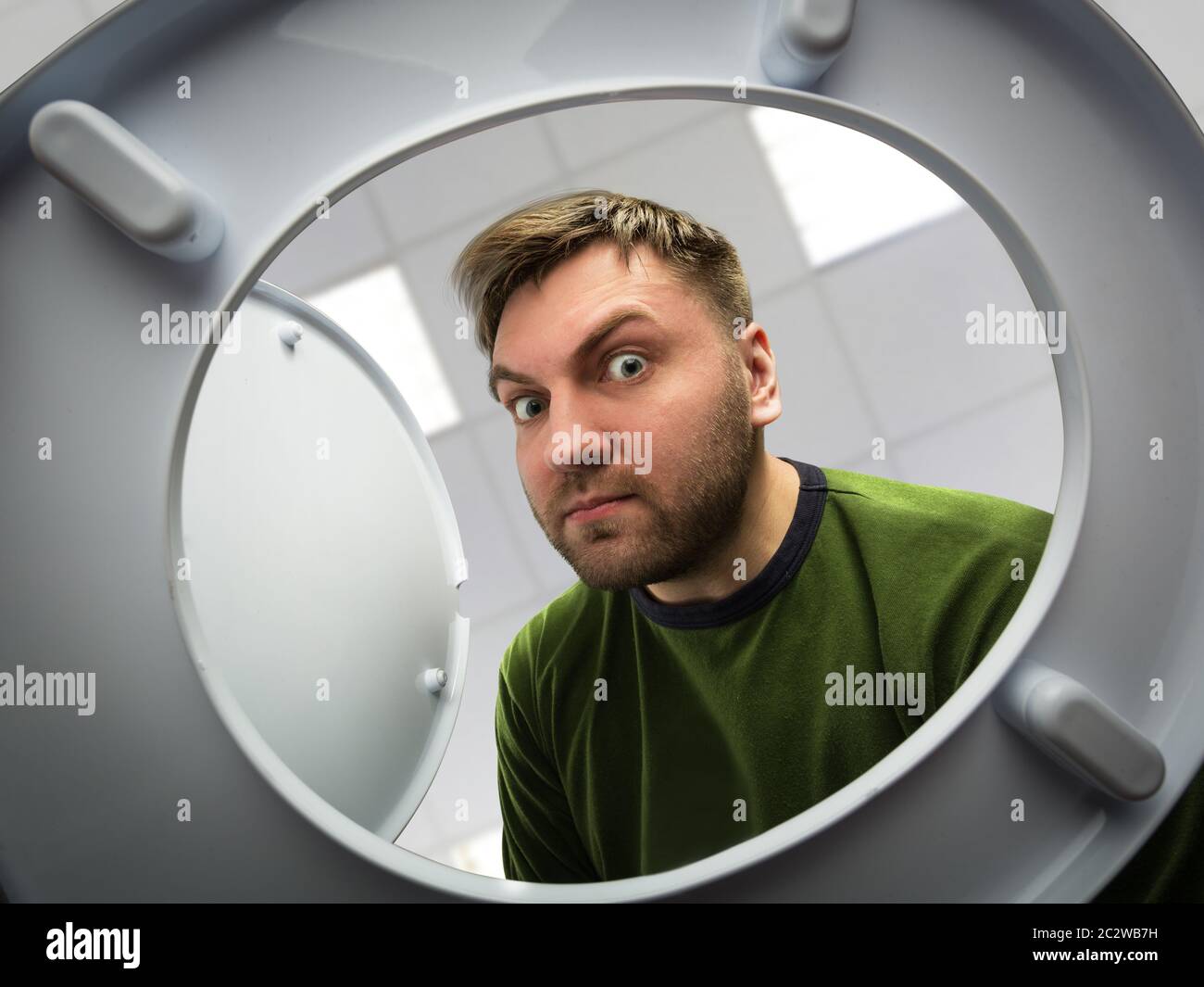 Man in the bathroom looking in the toilet bowl Stock Photo Alamy
