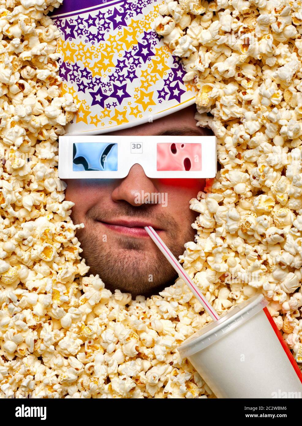 Happy face in popcorn with bucket on head watching 3D movie and drinking  soda Stock Photo - Alamy