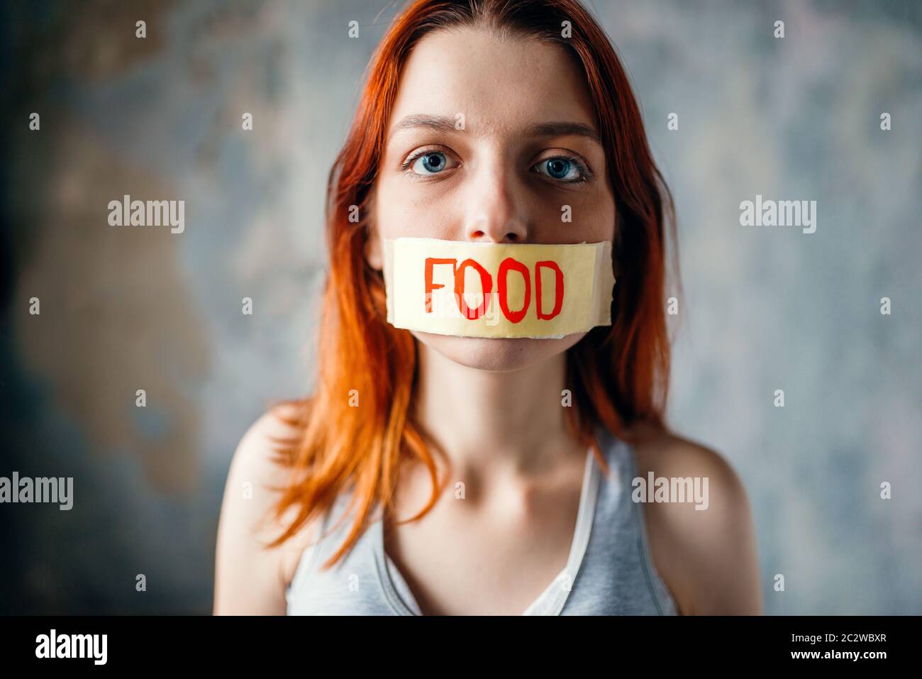 Womans face, mouth sealed with tape labeled food. Fat or calories burning concept. Weight loss, hard dieting, anorexia Stock Photo