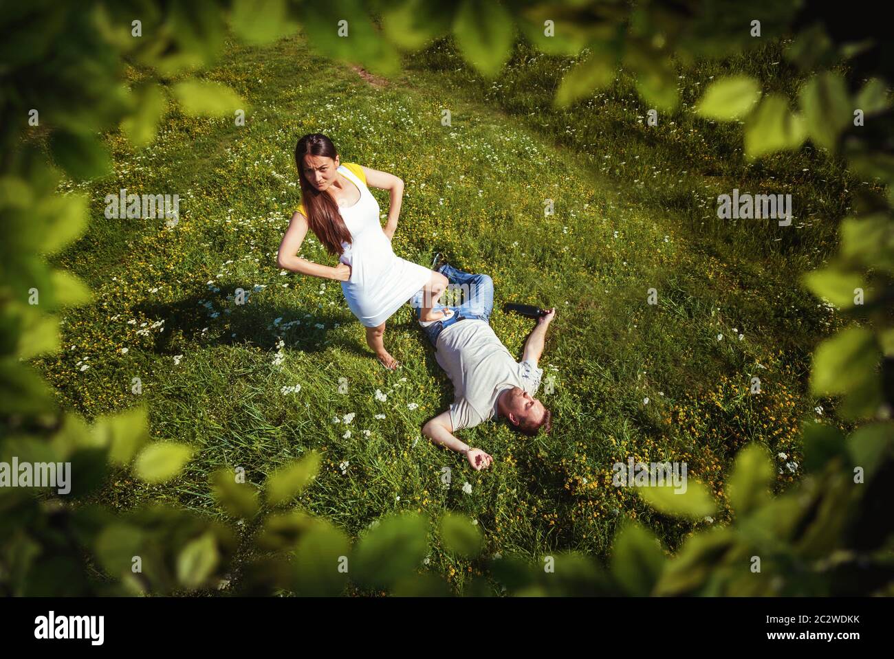 Top view of woman holding her foot on man's body on nature Stock Photo