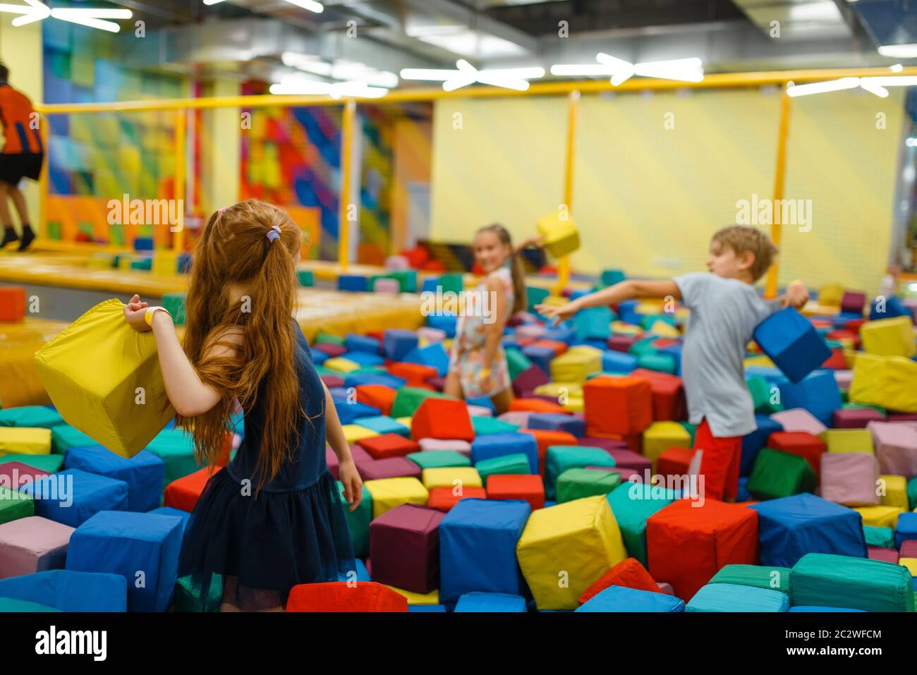 Little children playing with soft cubes, playground in entertainment center. Play area indoors
