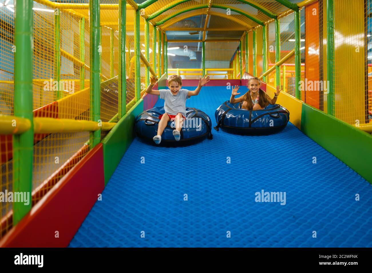Little children rides on tubing, playground in entertainment center