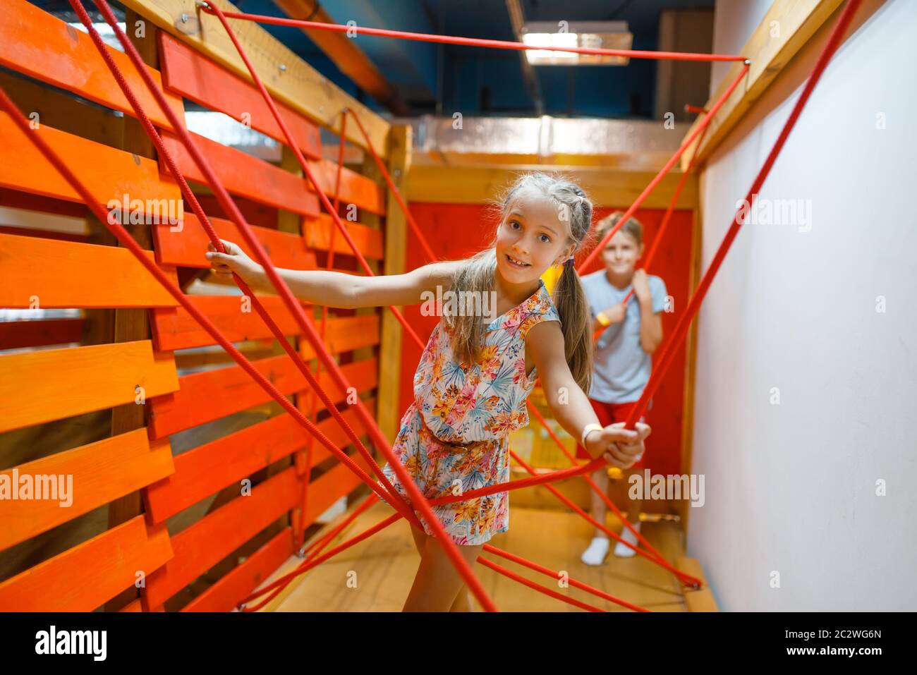 Two little girls playing in rope labyrinth, playground in entertainment ...
