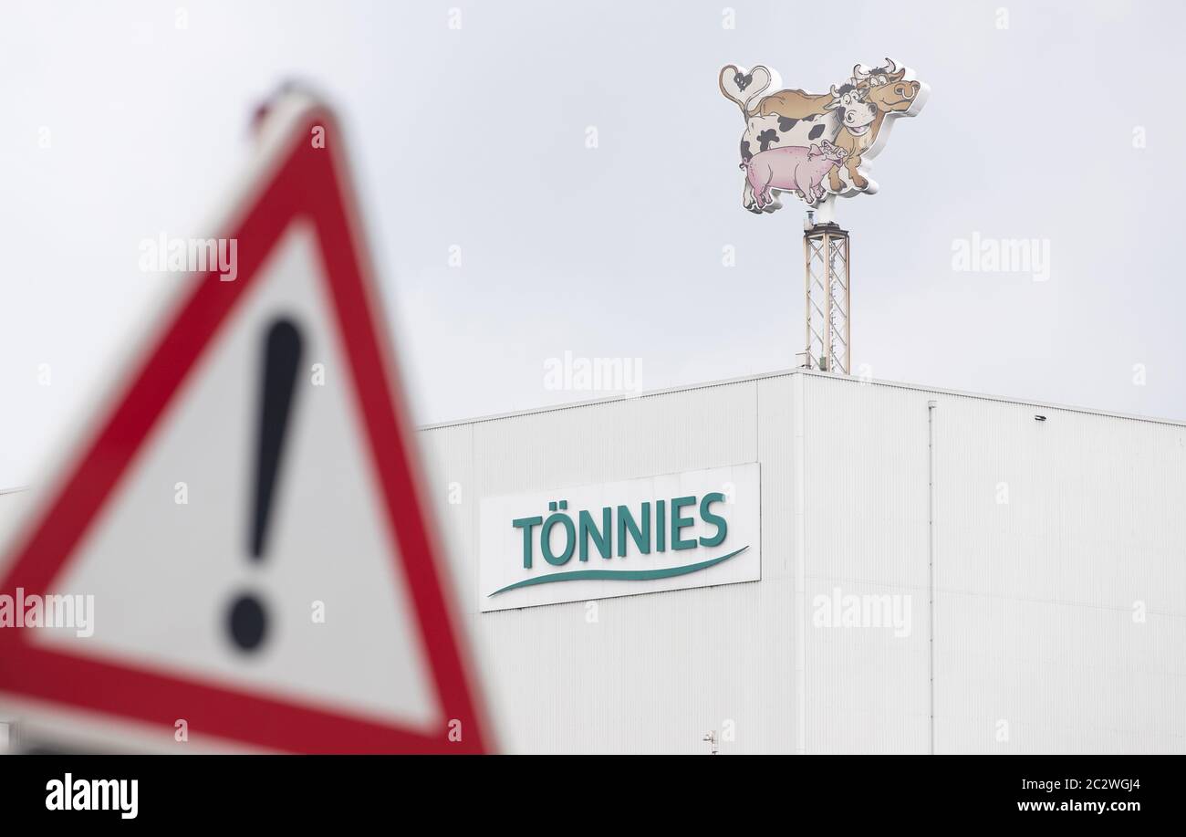 18 June 2020, North Rhine-Westphalia, Rheda-Wiedenbrück: View of a business logo of Tönnies on a production hall and behind a traffic sign ('Gefahrenstelle'). At the Tönnies slaughterhouse in Rheda-Wiedenbrück, hundreds of employees have been tested positive for the coronavirus since the beginning of the week. Photo: Friso Gentsch/dpa Stock Photo