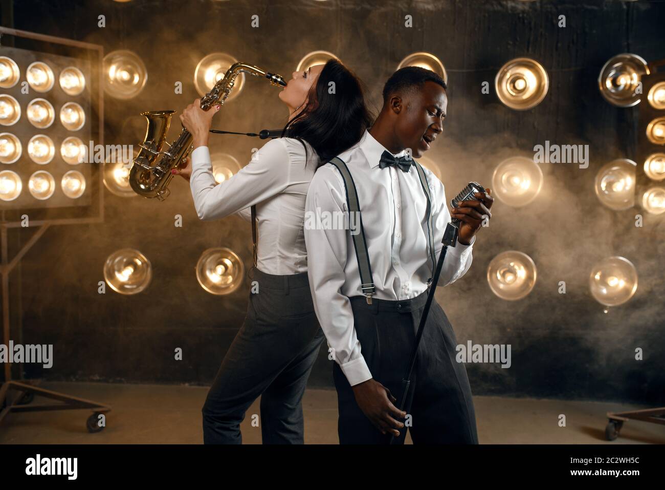 Male jazz performer and female saxophonist with saxophone, performing