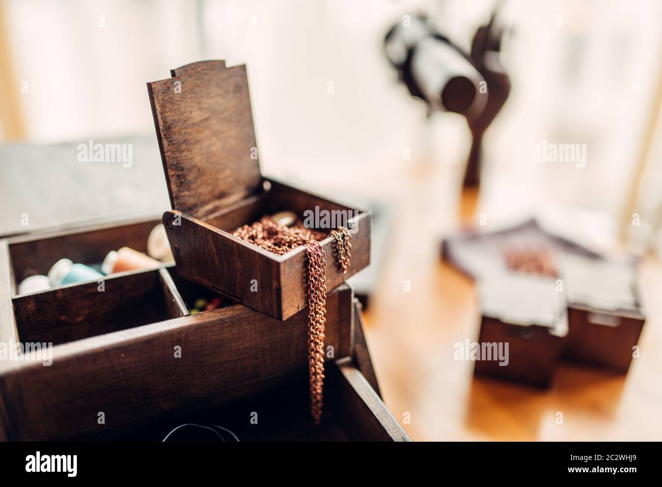 Needlework accessories, little metal rings in wooden box on the table, closeup, selective focuse, nobody. Handmade jewelry, bijouterie making Stock Photo