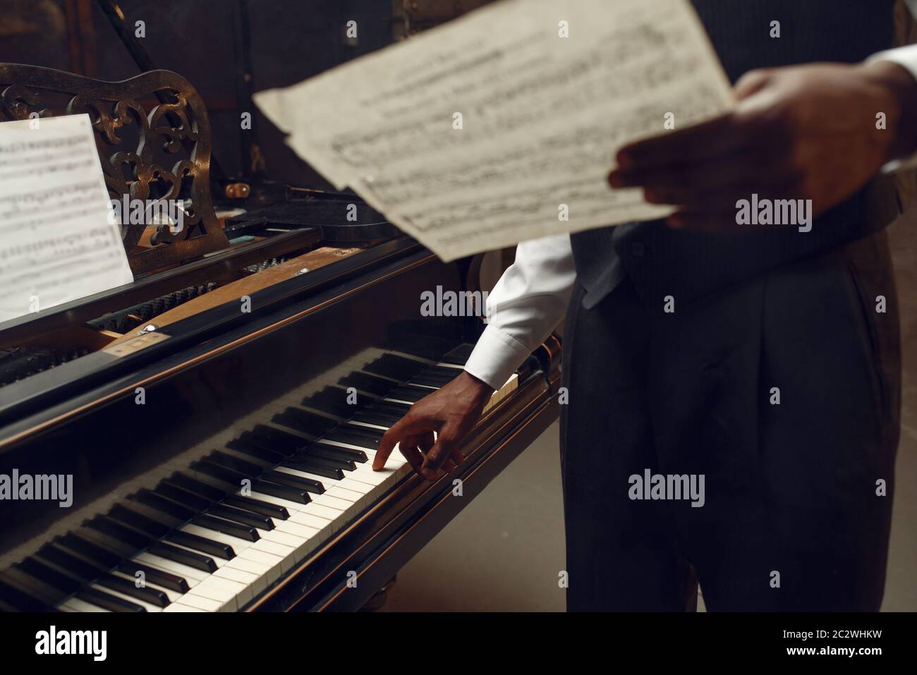 Black pianist with music notebook in his hands on the stage with ...