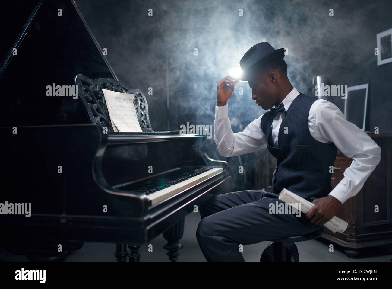 Ebony grand piano player, jazz musician. Negro performer poses at
