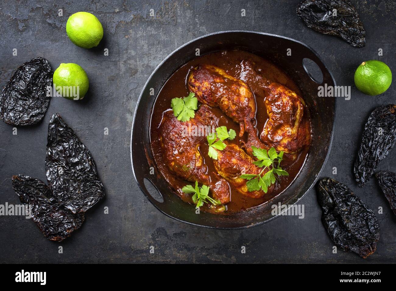 Traditional roasted Mexican pollo adobado chicken haunch with guajillo and hot ancho chilis as