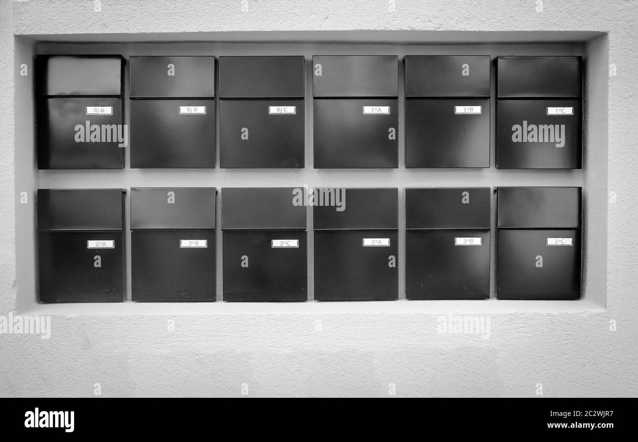 Mailboxes lined up in rows on a wall Stock Photo