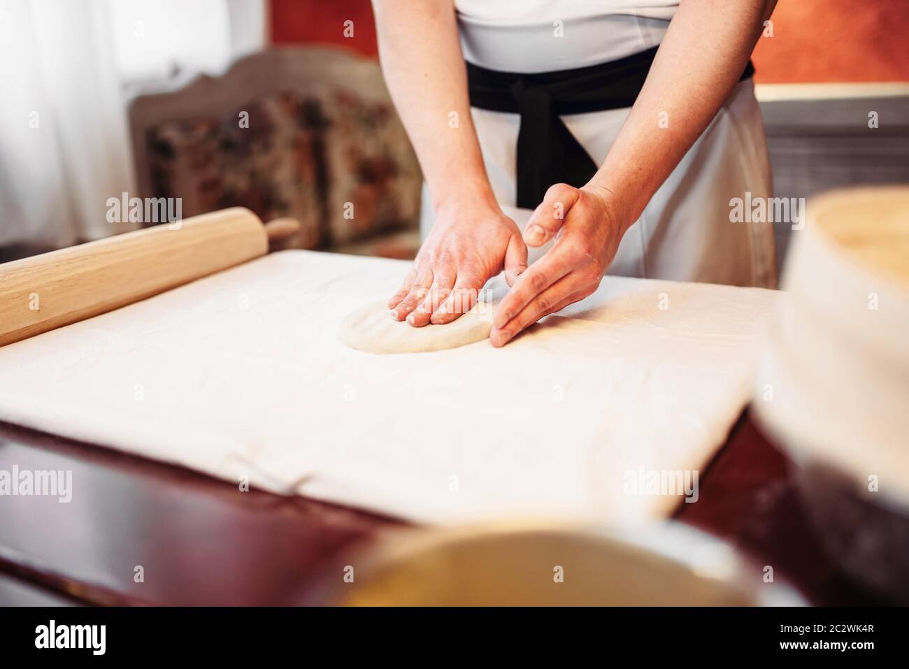 Male chef hands and dough on wooden table. Homemade strudel cooking ...