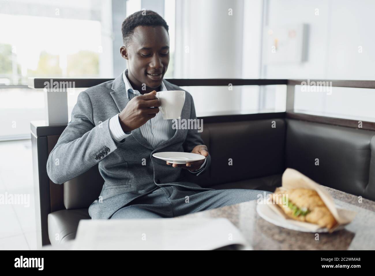 Young black businessman having lunch in office cafe. Successful business  person drinks coffee in food-court, black man in formal wear Stock Photo -  Alamy