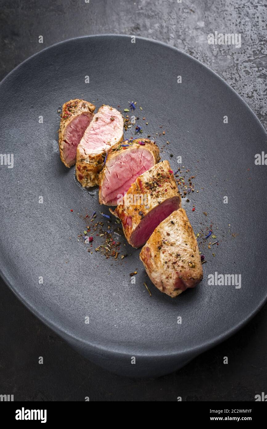 Fried Iberian pork fillet sliced with spice as closeup in a cast iron