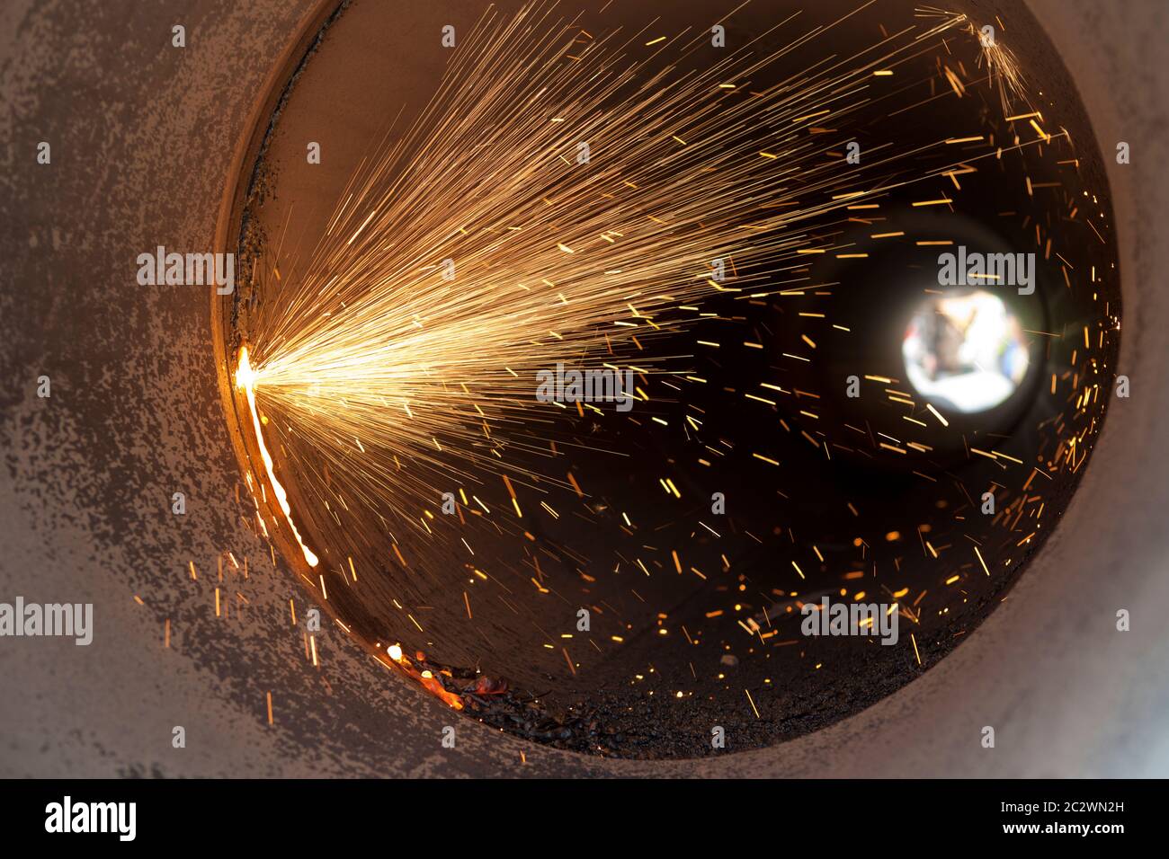 Welders using a gas torch to cut pipe during the construction of a
