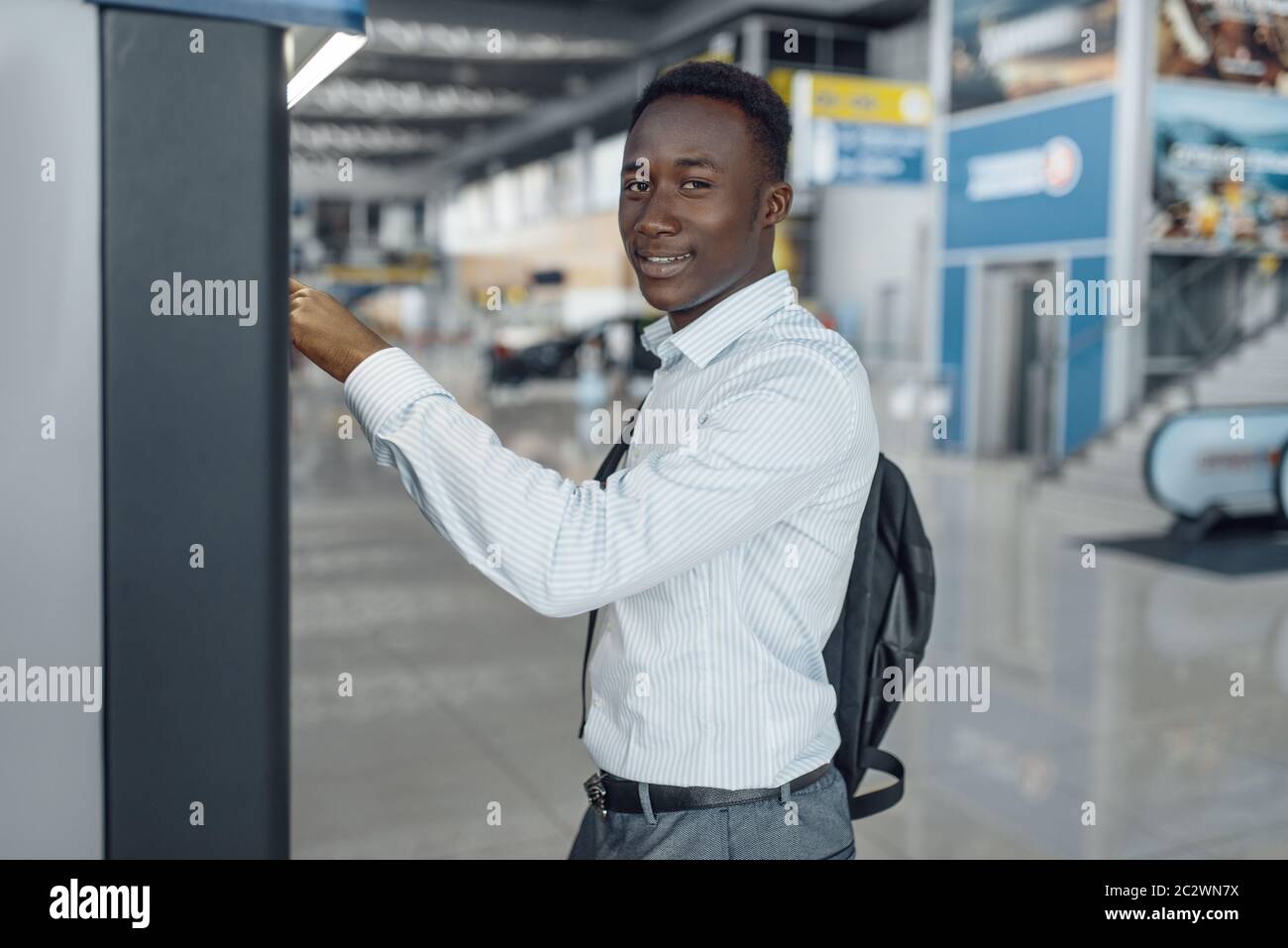 Black businessman at coffee machine in car dealership. Successful