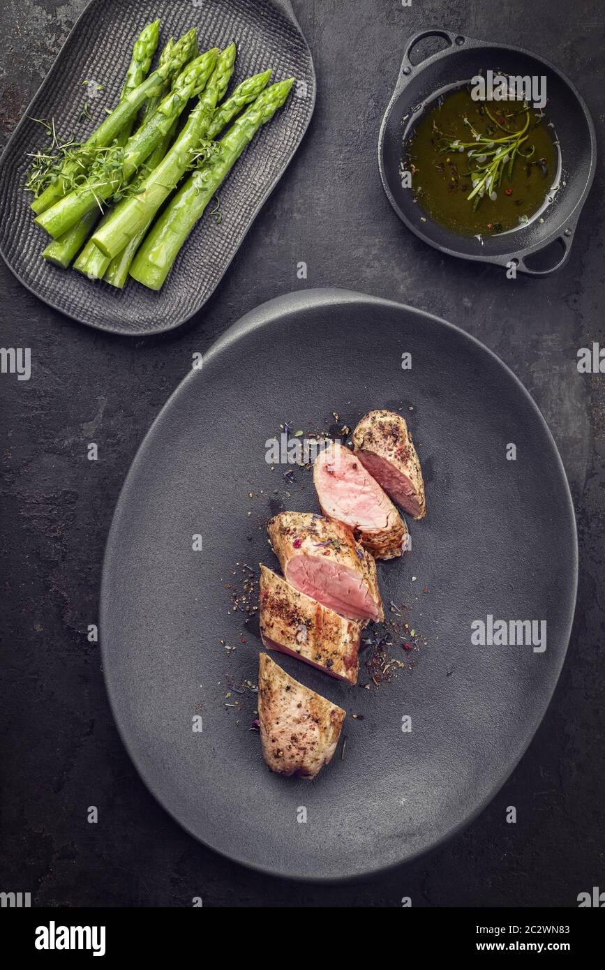 Fried Iberian pork fillet sliced with blanched green asparagus and ...